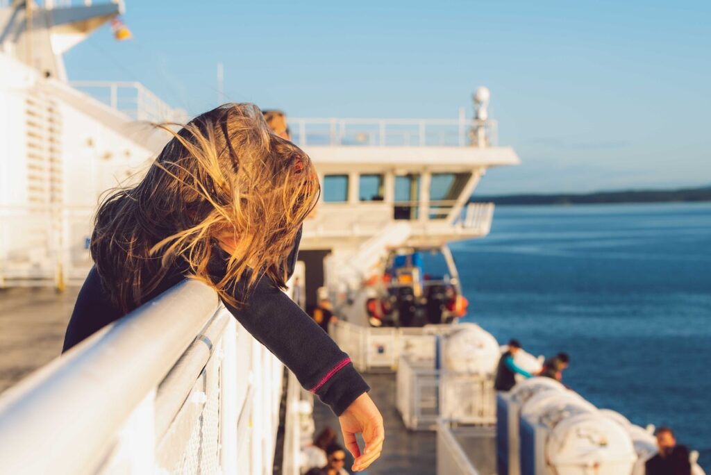 5 Tipps gegen Seekrankheit - Frau beugt sich am Shiff übers Geländer